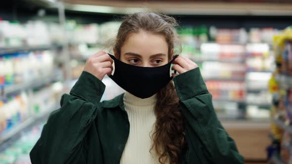 Woman Shopper Makes Purchases During the Coronavirus Epidemic Putting on Her Protective Mask