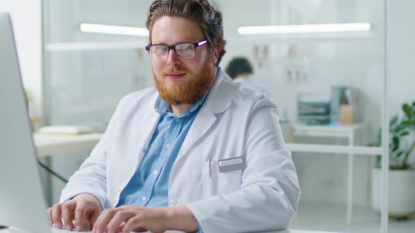 Portrait of Cheerful Doctor at Work in Clinic