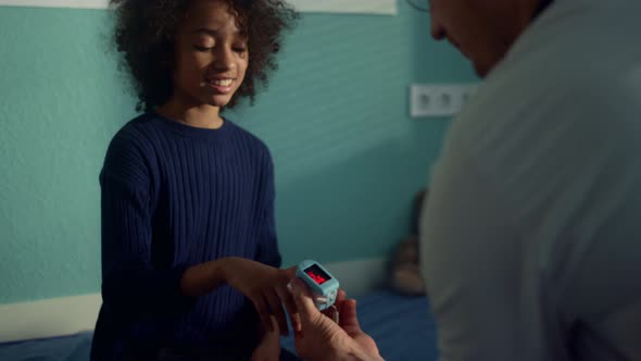 Physician Checking Blood Saturation Teen Girl Using Oximeter in Clinic Close Up