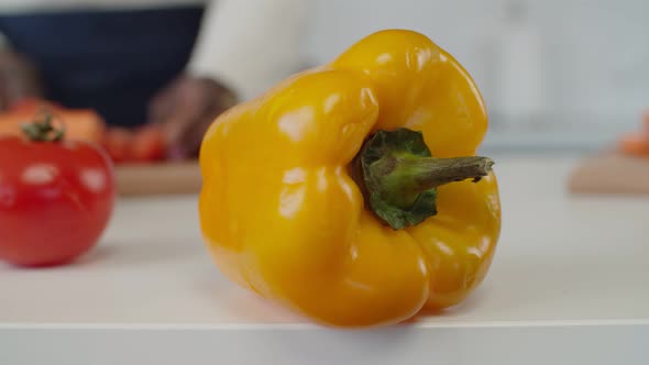 Female Hands Slicing Yellow Bell Pepper in Kitchen