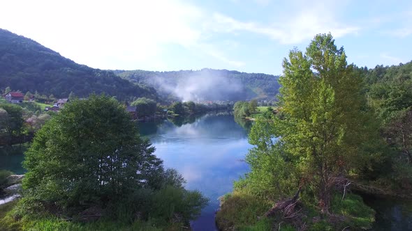 Flying above trees and clear water of Una river, Bosnia