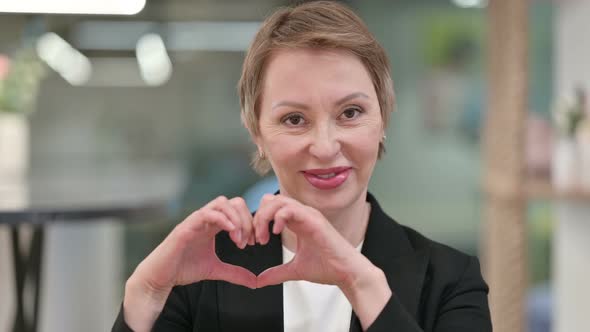 Old Businesswoman Showing Heart Sign with Hand