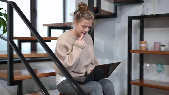 Medium Shot Thoughtful Teenage Girl Texting on Laptop Keyboard Messaging Online at Home