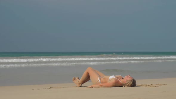 Woman Relaxes After Workout Lies on Back and Stretches Legs