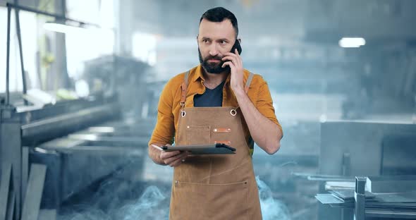 Factory Worker with Tablet and Phone at the Manufacturing