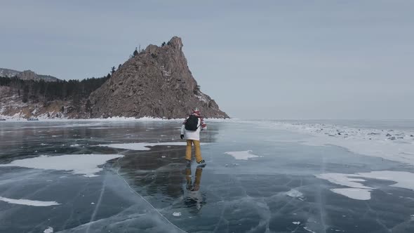 Aerial View of Man Skating on Lake Baikal Covered By Ice