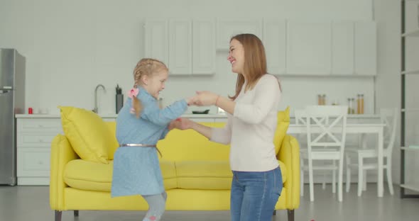 Joyful Little Girl with Mother Dancing Together