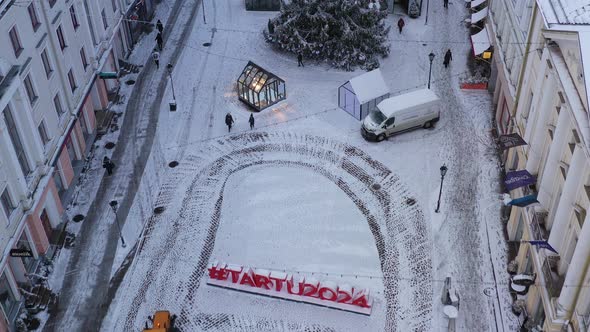 The tractor is removing snow from Tartus's old town square