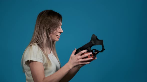 Surprised Woman Looks at Virtual Reality Headset