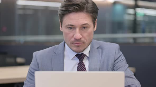 Close Up of Middle Aged Businessman working on Laptop 