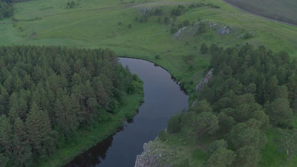 Aerial View of the River with a Rock and Forest on the Banks