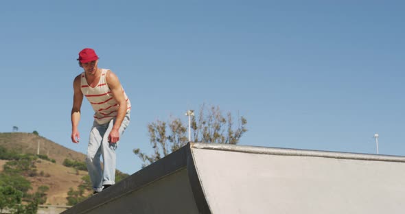 Caucasian man riding and jumping on skateboard on sunny day