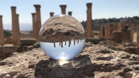 Crystal Ball Reflection Against Ancient Ruins of Roman City, Columns, Hand Holding