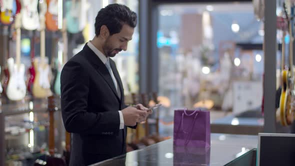 Young handsome man using smartphone and payment by smartphone contactless