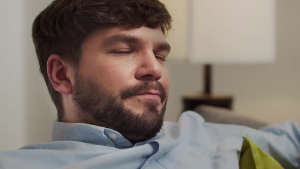 White Man with Glasses Rests on the Couch After Work