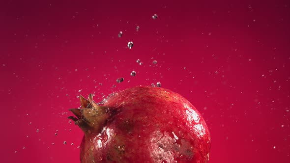 Flying of Pomegranate in Fuchsia Background in Slow Motion