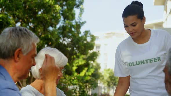 Happy volunteer interacting with senior people 4k