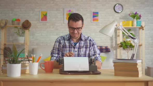 Man Writer Works at Home Throwing Sheets of Paper and Enthusiastically Typing on an Old Typewriter