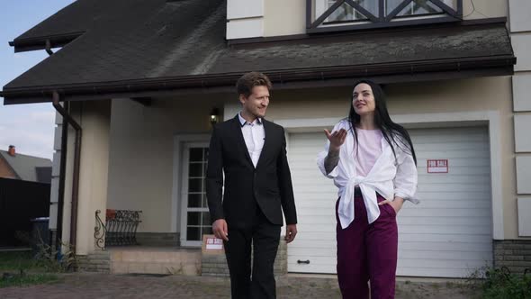 Confident Wealthy Couple Walking in Slow Motion Discussing Purchase of New House for Sale