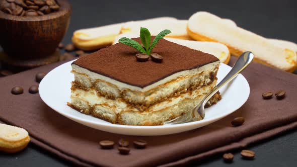 Portion of Traditional Italian Tiramisu dessert and savoiardi cookies