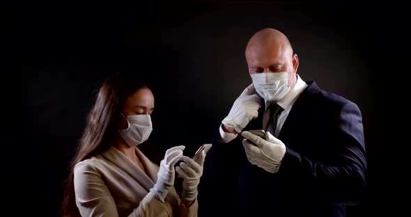 Portrait of a Couple on a Black Background. They Are Wearing Disposable Masks and Gloves and Holding