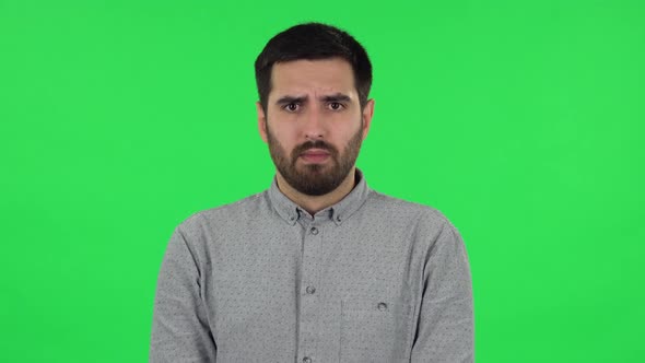 Portrait of Brunette Guy in Anticipation of Worries, Then Guilty Hides His Eyes. Green Screen