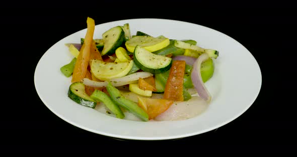 Grilled vegetables on a turntable. Carrot, pumpkin, pepper and onion.