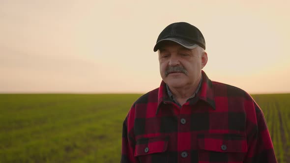 Portrait of a Tractor Farmer Walking Through a Field at Sunset After a Slowmotion Shoot