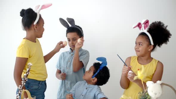 African American Kids in Funny Bunny Ears Colouring Eggs on Easter