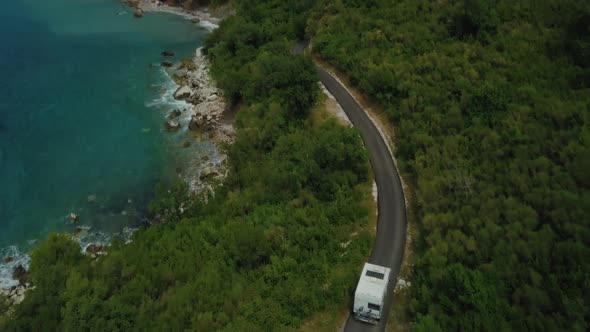 Aerial view of motorhome travelling on road with sea  background in Montenegro