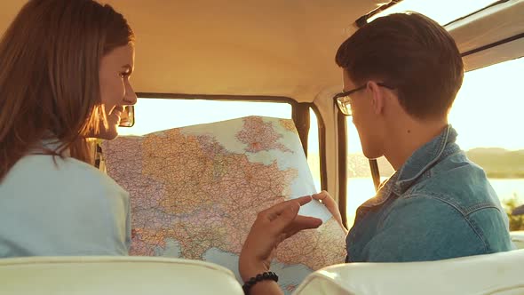 Friends Using Map Traveling In Car In Summer. Handsome Man And Beautiful Woman