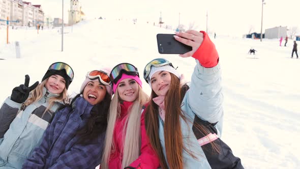 Women Snowboarders and Skiers on Mountain Slope Talking and Relaxing After Slide