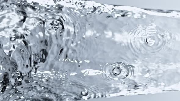 Super Slow Motion Detail Shot of Water Stream on Light Blue Background at 1000Fps