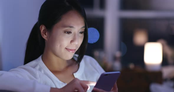 Woman use on cellphone at home in the evening