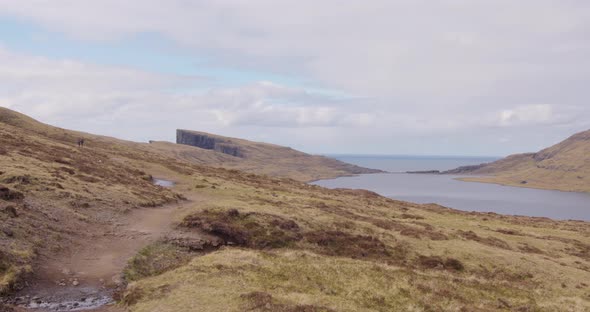 Wide Pan Right of the Lake Above the Ocean and Cliffside in the Faroe Islands