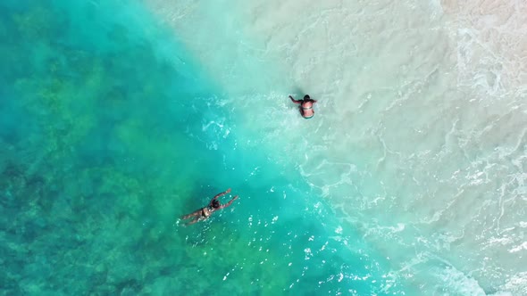 Beautiful ladies sunbathing on beautiful resort beach adventure by blue sea and white sandy backgrou