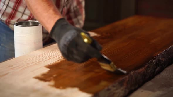 Man Is Applying Brown Lacquer on a Surface of Wooden Board, Painting Shop