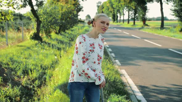 Traveler Young Woman Hitchhiking on Countryside Road.