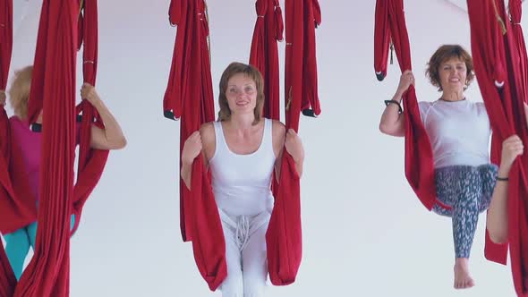 Nice Slim Women Have Fun Swinging in Hammocks in Room