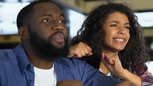 Black Couple Worrying About Sport Competition, Watching Game in Pub, Leisure