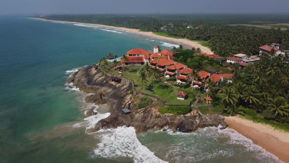 Travel to tropical resort. Luxurious hotel with a swimming pool on a rocky ocean shore. Paradise vac