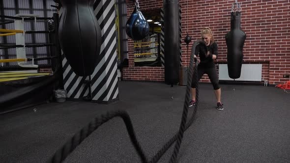 Powerful Attractive Muscular Woman Do Battle Workout with Ropes at the Gym