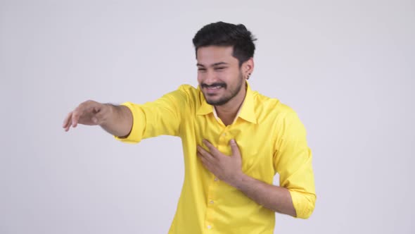 Young Happy Bearded Indian Businessman Laughing While Pointing Finger