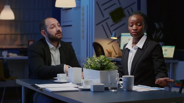 Diverse Businesspeople Discussing Management Company Solution Sitting at Conference Table