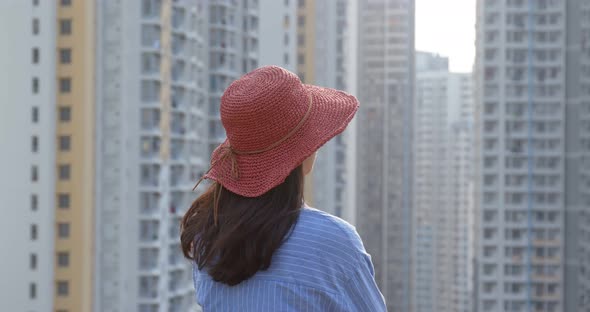 Woman wearing red straw hat and look around in the city