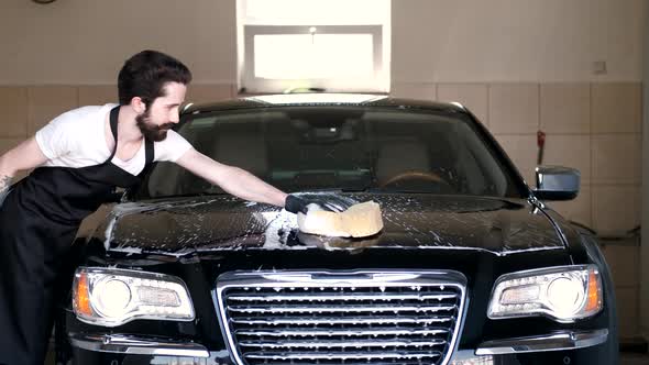 Man Washing His Car in a Garage