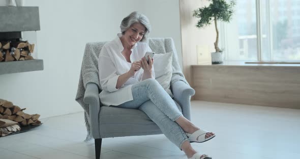 Relaxed Mature Old Woman Using Mobile Phone Applications