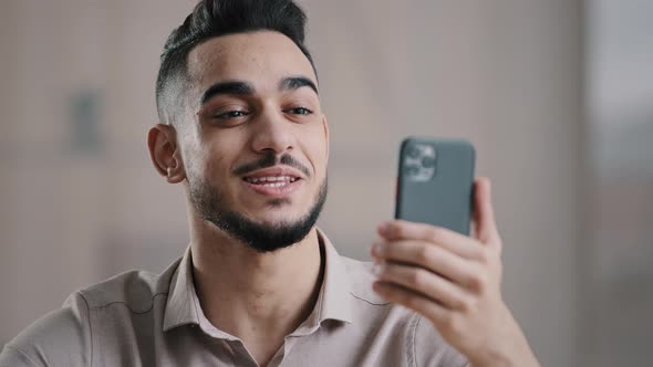 Happy Young Arabian Guy Business Man Male Worker Hold Smartphone Talk By Video Call Greeting Have