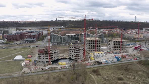 Construction site with tower cranes in Prague city, car traffic behind.