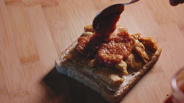 Putting Pizza Sauce On Top Of Fried Chicken Breast In Whole Grain Toast. Fat Loss Sandwich. close up